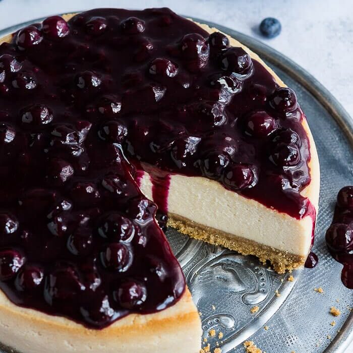 Vegan lemon blueberry cheesecake - this delicious eggless and dairy free baked cheesecake is easy to make and tastes amazing! The perfect dessert for Summer! #veganbaking #cheesecake #eggless #dairyfree #veg